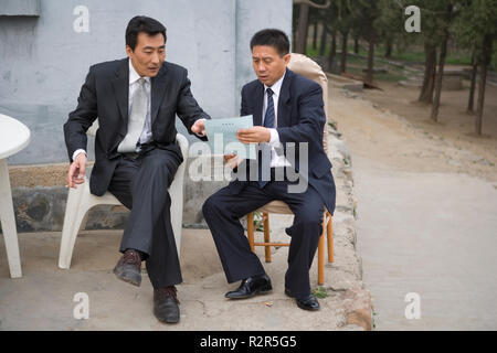 Two businessmen having a discussion while looking at a document. Stock Photo