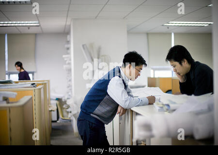 Two young businessmen looking at documents inside an office. Stock Photo
