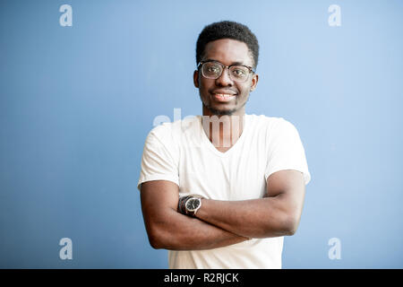 Portrait of a young african man dressed in white t-shirt standing on the colorful background Stock Photo