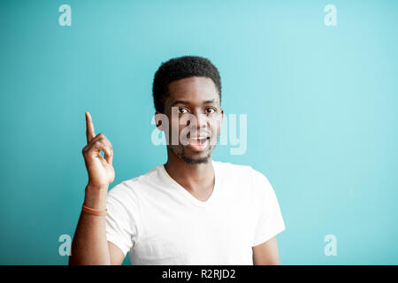 Portrait of a young african man dressed in white t-shirt having an idea on the colorful background Stock Photo