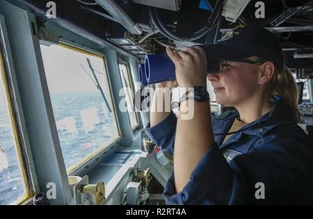 ATLANTIC OCEAN (Nov. 6, 2018) Ens. Taylor Brunstad observes the Atlantic Ocean during an Integrated Maritime Portable Acoustic Sound Scoring (IMPASS) system evolution aboard the Arleigh Burke-class guided-missile destroyer USS Nitze (DDG 94). IMPASS certification recognizes a ship’s ability to support ground forces by accurately firing a MK-45 5-inch/54-caliber gun. USS Abraham Lincoln (CVN 72) carrier strike group (CSG) cruiser-destroyer (CRUDES) units participate in the first East Coast CRUDES Surface Warfare Advanced Tactical Training (SWATT). SWATT is led by the Naval Surface and Mine Warf Stock Photo