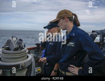 ATLANTIC OCEAN (Nov. 6, 2018) Ens. Taylor Brunstad and Lt. j. g. Brittany Leonard make reports to the ship’s helmsman during an Integrated Maritime Portable Acoustic Sound Scoring (IMPASS) system evolution aboard the Arleigh Burke-class guided-missile destroyer USS Nitze (DDG 94). IMPASS certification recognizes a ship’s ability to support ground forces by accurately firing a MK-45 5-inch/54-caliber gun. USS Abraham Lincoln (CVN 72) carrier strike group (CSG) cruiser-destroyer (CRUDES) units participate in the first East Coast CRUDES Surface Warfare Advanced Tactical Training (SWATT). SWATT is Stock Photo