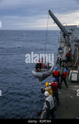 ATLANTIC OCEAN (Nov. 6, 2018) Sailors retrieve one of the ship's Rigid-hulled Inflatable Boats (RIB) during an Integrated Maritime Portable Acoustic Sound Scoring (IMPASS) system evolution aboard the Arleigh Burke-class guided-missile destroyer USS Nitze (DDG 94). IMPASS certification recognizes a ship’s ability to support ground forces by accurately firing a MK-45 5-inch/54-caliber gun. USS Abraham Lincoln (CVN 72) carrier strike group (CSG) cruiser-destroyer (CRUDES) units participate in the first East Coast CRUDES Surface Warfare Advanced Tactical Training (SWATT). SWATT is a training exerc Stock Photo