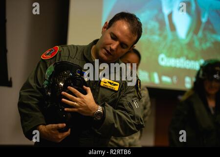 Maj. Fernando Perez, 61st Fighter Squadron, director of weapons, briefs members of the Personalized Learning Cohort about an F-35A Lightning II helmet during a visit to Luke Air Force Base, Ariz., Nov. 2, 2018. Throughout the tour, members of the cohort were given the opportunity to speak with Airmen and receive a comprehensive review of some of the resources and tools used to train fighter pilots. Stock Photo