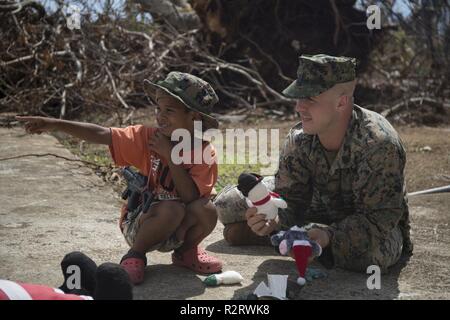 Staff Sgt. Joseph Colvin, an ammunition technician with Combat Logistics Battalion 31, speaks with a Tinian resident during U.S. Defense Support of Civil Authorities relief efforts on Tinian, Commonwealth of the Northern Mariana Islands, Nov. 6, 2018. Colvin, a native of, Croydon, Pennsylvania, graduated from Bucks County Technical High School in June 2006 before enlisting in August 2007. Businesses, government buildings, homes and schools were heavily damaged by Super Typhoon Yutu, which made a direct hit with devastating effect on Tinian Oct. 25 as the second strongest storm to ever hit U.S. Stock Photo