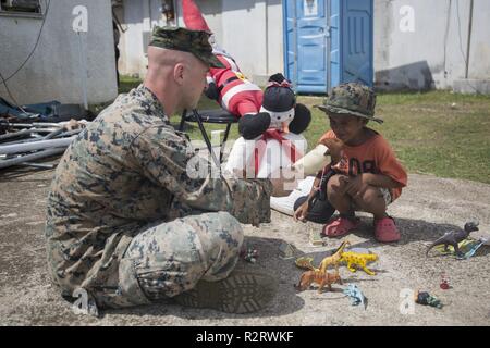 Staff Sgt. Joseph Colvin, an ammunition technician with Combat Logistics Battalion 31, speaks with a Tinian resident during U.S. Defense Support of Civil Authorities relief efforts on Tinian, Commonwealth of the Northern Mariana Islands, Nov. 6, 2018. Colvin, a native of, Croydon, Pennsylvania, graduated from Bucks County Technical High School in June 2006 before enlisting in August 2007. Businesses, government buildings, homes and schools were heavily damaged by Super Typhoon Yutu, which made a direct hit with devastating effect on Tinian Oct. 25 as the second strongest storm to ever hit U.S. Stock Photo