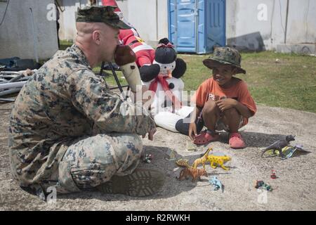 Staff Sgt. Joseph Colvin, an ammunition technician with Combat Logistics Battalion 31, speaks with a Tinian resident during U.S. Defense Support of Civil Authorities relief efforts on Tinian, Commonwealth of the Northern Mariana Islands, Nov. 6, 2018. Colvin, a native of, Croydon, Pennsylvania, graduated from Bucks County Technical High School in June 2006 before enlisting in August 2007. Businesses, government buildings, homes and schools were heavily damaged by Super Typhoon Yutu, which made a direct hit with devastating effect on Tinian Oct. 25 as the second strongest storm to ever hit U.S. Stock Photo