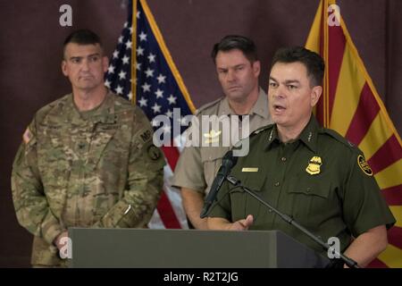 Border Patrol Tucson Sector Chief Rodolfo Karisch speaks at the Joint CBP and DOD Briefing on Operation Secure Line at the Port of Nogales on November 9, 2018. Shown behind him is Jessie Scruggs, Deputy Director Air and Marine Operations Tucson and Col. Larry C. Dewey, commander, 16th Military Police Brigade. Customs and Border Protection Stock Photo