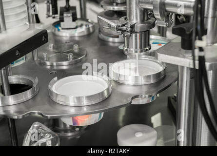 production and bottling of yogurt in plastic cups. equipment at the dairy plant Stock Photo