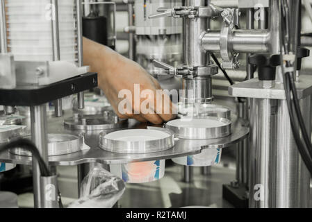production and bottling of yogurt in plastic cups. equipment at the dairy plant Stock Photo