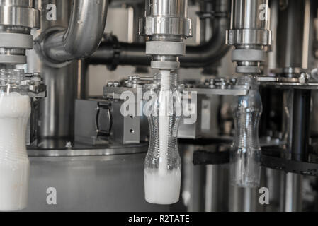 filling milk in to plastic bottles at the factory. equipment at the dairy plant Stock Photo