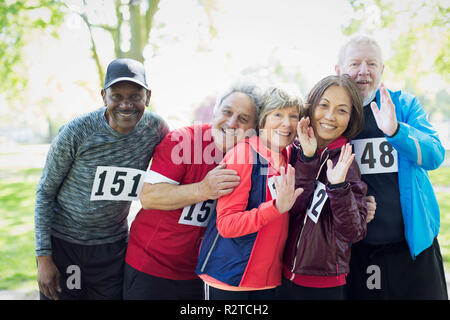Portrait confident active senior runner friends wearing sports race bibs Stock Photo