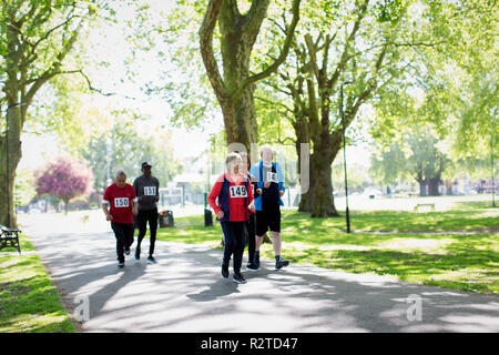 Active seniors running sports race in park Stock Photo