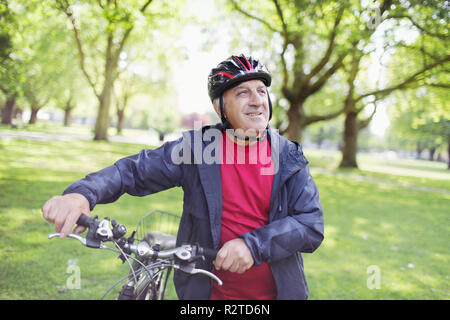 Active senior man riding bike in park Stock Photo