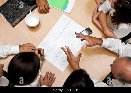 Group of architects brainstorming around a conference table. Stock Photo