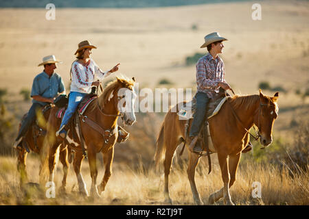 Smiling family horseback riding on a ranch. Stock Photo