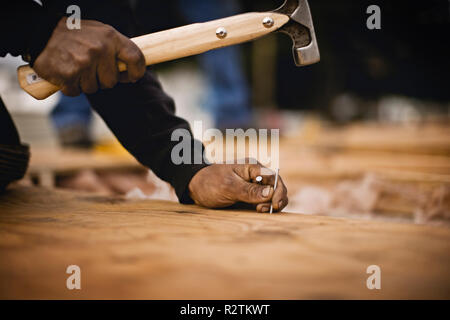 Construction worker hammering in nails Stock Photo