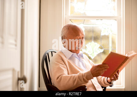 Portrait of senior man reading a book. Stock Photo