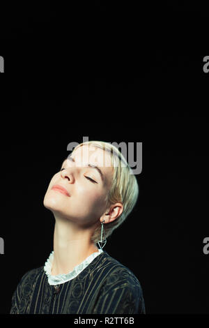 Serene young woman with eyes closed and head back Stock Photo