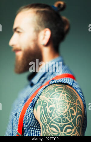 Close up hipster man with shoulder tattoo and beard Stock Photo