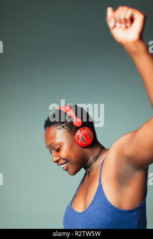 Carefree woman with headphones dancing, listening to music Stock Photo