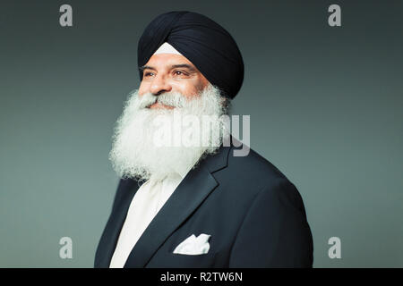 Portrait confident, well-dressed senior man with beard wearing turban Stock Photo