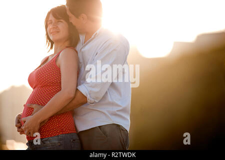 Twenty-Something man hugs his pregnant wife Stock Photo - Alamy