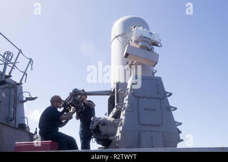 PACIFIC OCEAN (Nov. 03, 2018) Fire Controlman 2nd Class Jacob Hathcote, from Houston, and Fire Controlman 3rd Class Chais Fuller, from Durham, North Carolina, inspect the gun assembly of a Phalanx close-in weapons system (CIWS) aboard the Arleigh Burke-class guided-missile destroyer USS Spruance (DDG 111). Spruance is currently conducting routine operations as part of Carrier Strike Group (CSG) 3 in the U.S. Pacific Fleet area of operations. Stock Photo