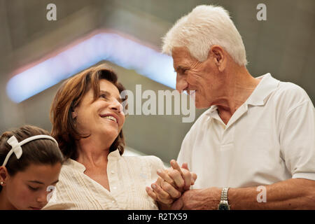 Loving mature couple holding hands, looking at each other. Stock Photo