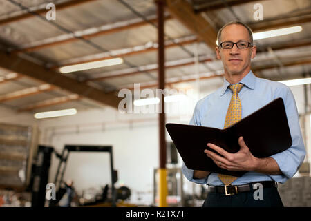 Portrait of a serious businessman holding a notepad. Stock Photo