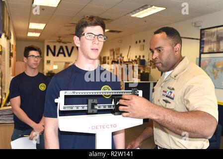 NEW BRAUNFELS, Texas – (October 30, 2018) Electronics Technician (Submarines) 1st Class Vincent Barnes of Chicago assigned to Navy Recruiting Station (NRS) New Braunfels, Navy Recruiting District (NRD) San Antonio conducts a height and weight measurements of future Sailor Jack Lanier of Universal City, Texas, while his twin brother, James Lanier observes during their 72-hour indoctrination at the NRS.  The Lanier brothers are seniors at Marion High School in Marion, Texas, and joined the Navy in the Nuclear Propulsion Program which currently is awarding bonuses of up to $40,000.  Barnes is a g Stock Photo