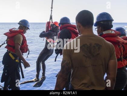 MEDITERRANEAN SEA (Nov. 5, 2018) Sailors assigned to the San Antonio-class amphibious transport dock ship USS Anchorage (LPD 23) lower a search and rescue swimming during a simulated man over board drill in the Mediterranean Sea, Nov. 5, 2018. Anchorage and embarked 13th Marine Expeditionary Unit are deployed to the U.S. 6th Fleet area of operations as a crisis response force in support of regional partners as well as to promote U.S. national security interests in Europe and Africa. Stock Photo