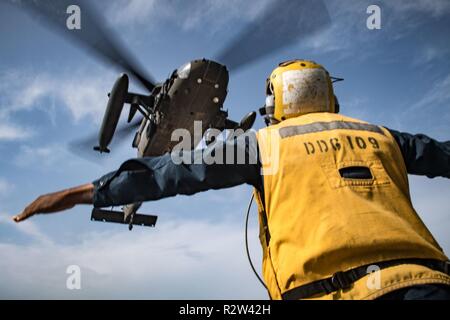 ARABIAN GULF (Nov. 7, 2018) Boatswain’s Mate 2nd Class Archangel Smiley signals a U.S. Army UH-60 Black Hawk helicopter, assigned to “Shiner” of 1st Battalion, 108th Aviation Regiment, to lift off from the flight deck of the guided-missile destroyer USS Jason Dunham (DDG 109). Jason Dunham is deployed to the U.S. 5th Fleet area of operations in support of naval operations to ensure maritime stability and security in the Central Region, connecting the Mediterranean and the Pacific through the western Indian Ocean and three strategic choke points. Stock Photo