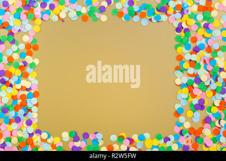 Frame of colorful confetti on yellow background. Stock Photo