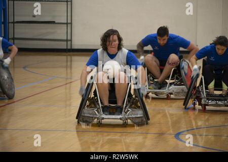 Retired Captain Kelly Patterson moves quickly up the court during wheelchair rugby practice at the NE Region Warrior CARE Event at Joint Base Andrews, MD. She competed at the 2017 Warrior Games and hopes to get on the Team US for Invictus Games in 2020. The biggest moving part of the AFW2 Warrior CARE Events is the adaptive sports. It's dynamic and fast-moving, giving each warrior an opportunity to see what they can do versus what they cannot. These wounded warriors often come to the events with a prescribed lists of things they cannot do and the coaching staff work hard to move around those m Stock Photo