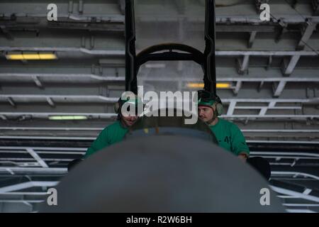 PACIFIC OCEAN (Nov. 10, 2018) Aviation Electrician’s Mate 3rd Class Daniel Woodard, left, from Farmington, Connecticut, and Aviation Electrician’s Mate 3rd Class Jared Person, from Galt, California, perform maintenance on an F/A-18F Super Hornet, with Strike Fighter Squadron (VFA) 41, in the hangar bay aboard the Nimitz-class aircraft carrier USS John C. Stennis (CVN 74). John C. Stennis is underway conducting routine operations in the U.S. Pacific Fleet area of operations. Stock Photo