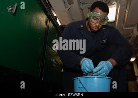PACIFIC OCEAN (Nov. 9, 2018) Aviation Support Equipment Technician 2nd Class Willie Mozie, from Alexandria, Louisiana, strips grease from a gear in the Gas Systems Equipment shop aboard the Nimitz-class aircraft carrier USS John C. Stennis (CVN 74). John C. Stennis is underway conducting routine operations in the U.S. Pacific Fleet area of operations. Stock Photo