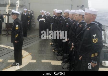 PACIFIC OCEAN (Nov. 9, 2018) A firing detail stands at attention during a burial at sea ceremony aboard the Arleigh Burke-class guided-missile destroyer USS Spruance (DDG 111). Spruance is underway conducting routine operations as part of Carrier Strike Group (CSG) 3 in the U.S. Pacific Fleet area of operations. Stock Photo