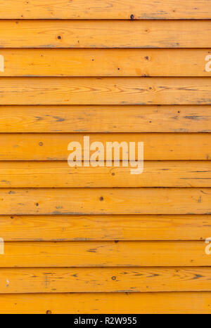 Horizontal old wood fence background. Old wooden planks with bright yellow paint. Vertical photo Stock Photo