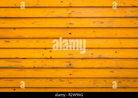 Horizontal old wood fence background. Old wooden planks with bright yellow paint Stock Photo