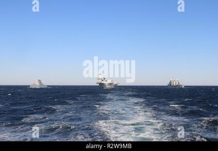 (Nov. 11, 2018) ATLANTIC OCEAN – Zumwalt-class guided-missile destroyer Pre-Commissioning Unit (PCU) Michael Monsoor (DDG 1001), British aircraft carrier HMS Queen Elizabeth (R08), and Tide-class replenishment tanker Royal Fleet Auxiliary (RFA) Tidespring (A136) conduct a photo exercise, Nov. 11.  The future USS Michael Monsoor is the second ship in the Zumwalt-class of guided-missile destroyers and is transiting to San Diego. Stock Photo