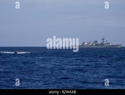 ATLANTIC OCEAN (Nov. 8, 2018) A rigid-hull inflatable boat, left, assigned to the Arleigh Burke-class guided-missile destroyer USS Gonzalez (DDG 66), conducts small boat operations with the Royal Canadian Navy Halifax-class frigate HMCS St. John's (FFH 340). Abraham Lincoln Carrier Strike Group (CSG) cruiser-destroyer (CRUDES) units are completing a Surface Warfare Advanced Tactical Training exercise (SWATT). SWATT is led by the Naval Surface and Mine Warfighting Development Center and is designed to increase warfighting proficiency, lethality and interoperability of participating units. Stock Photo