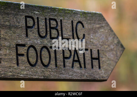 Closeup photo of old wooden, gray, black 'public footpath' sign. Stock Photo