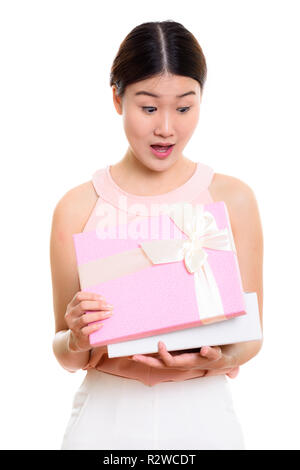 Young beautiful Asian woman opening gift box while looking surpr Stock Photo