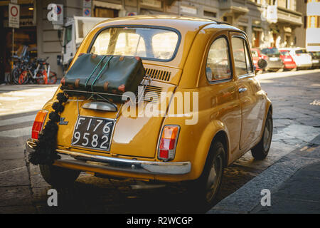 Florence, Italy - February, 2019. Yellow vintage Fiat 500 parked in the street of the historical town centre. Stock Photo