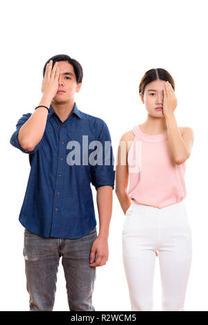 Studio shot of young Asian couple covering face together Stock Photo