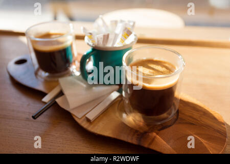 Wooden tray with two cups of coffee on the table in front of the window Stock Photo