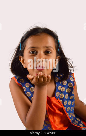 Little girl giving a flying kiss looking at camera. Pune, Maharashtra Stock Photo