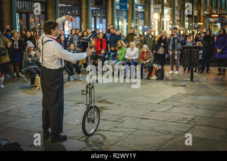 London, UK - February, 2019. A street juggler performing in Covent Garden Market in front of a crowd of tourists. Stock Photo