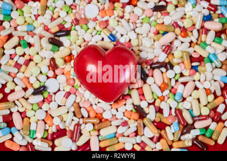 Red heart lies on many colorful medicines Stock Photo